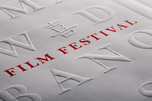 image of a crop of ang lee film festival poster, debossed letters on white paper with red type